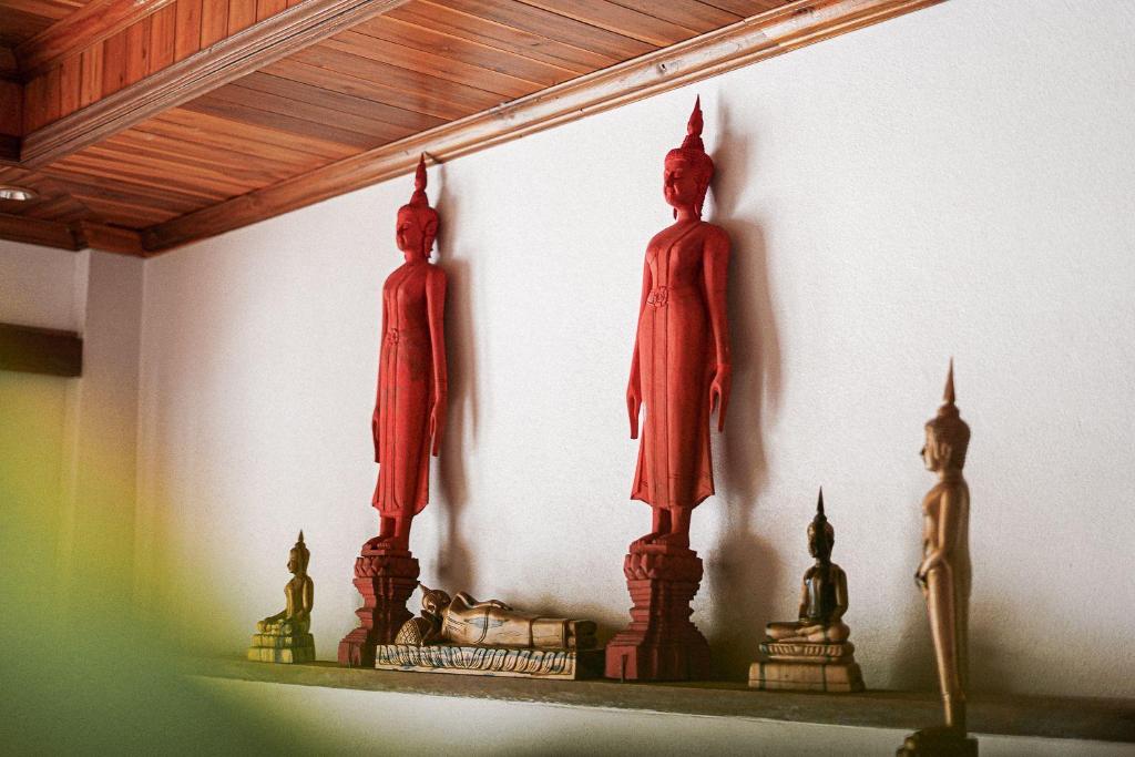 two statues on a shelf in a room at Villa Wanika in Luang Prabang