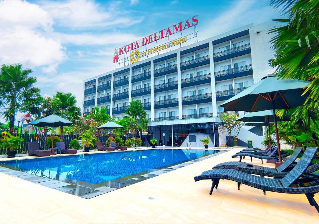 a hotel with a swimming pool in front of a building at Le Premier Hotel Deltamas in Cikarang