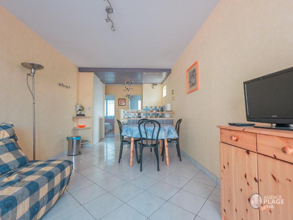 sala de estar con mesa y TV en Appartement Les Sables-d'Olonne, 2 pièces, 4 personnes - FR-1-197-547, en Les Sables-dʼOlonne