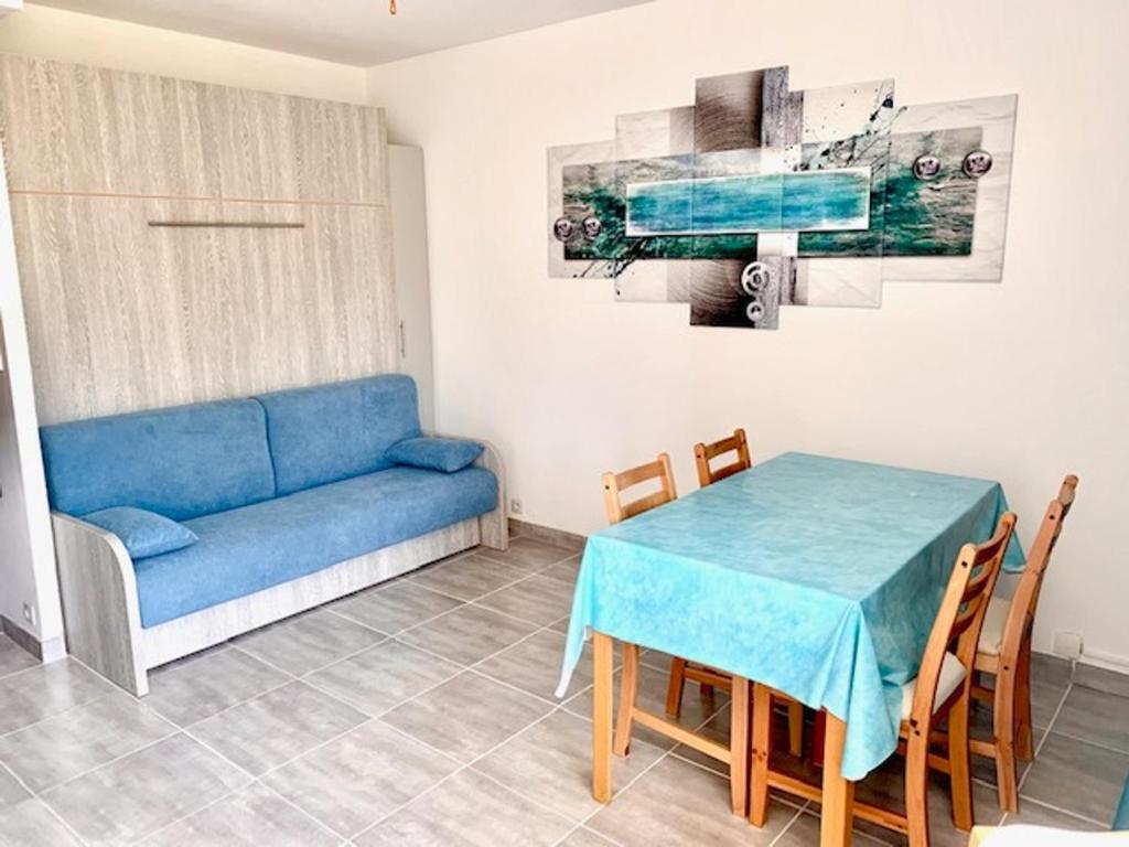 salon z niebieską kanapą i stołem w obiekcie Studio climatisé avec garage et WiFi à 5 min des Thermes - FR-1-503-157 w mieście Balaruc-les-Bains