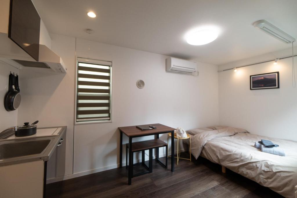 a bedroom with a bed and a table and a sink at 5963 Hotel Higashi Ikebukuro in Tokyo