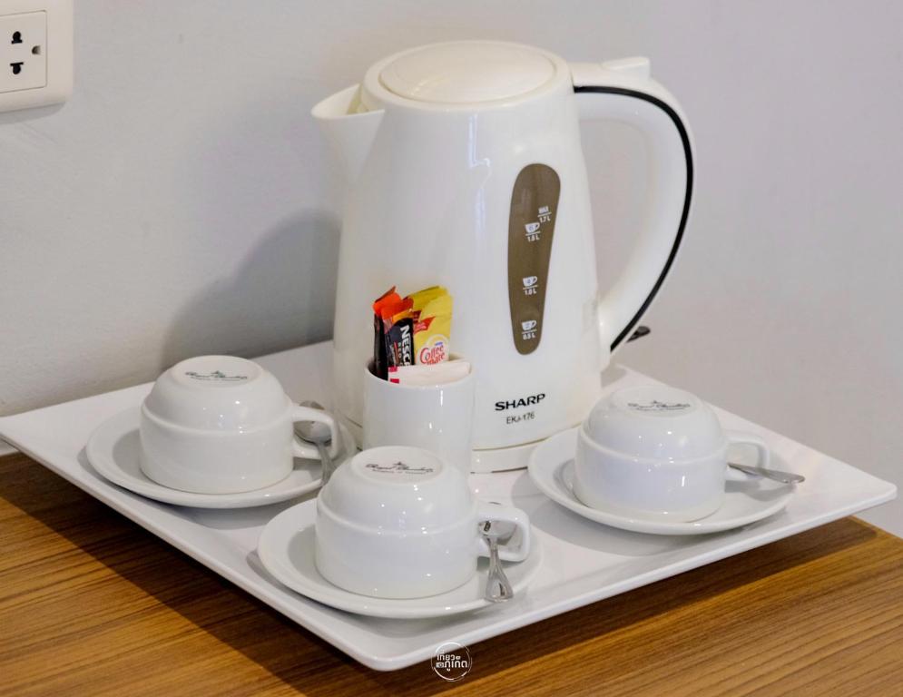 a white tea kettle and saucers on a tray at Days Inn by Wyndham Patong Beach in Patong Beach