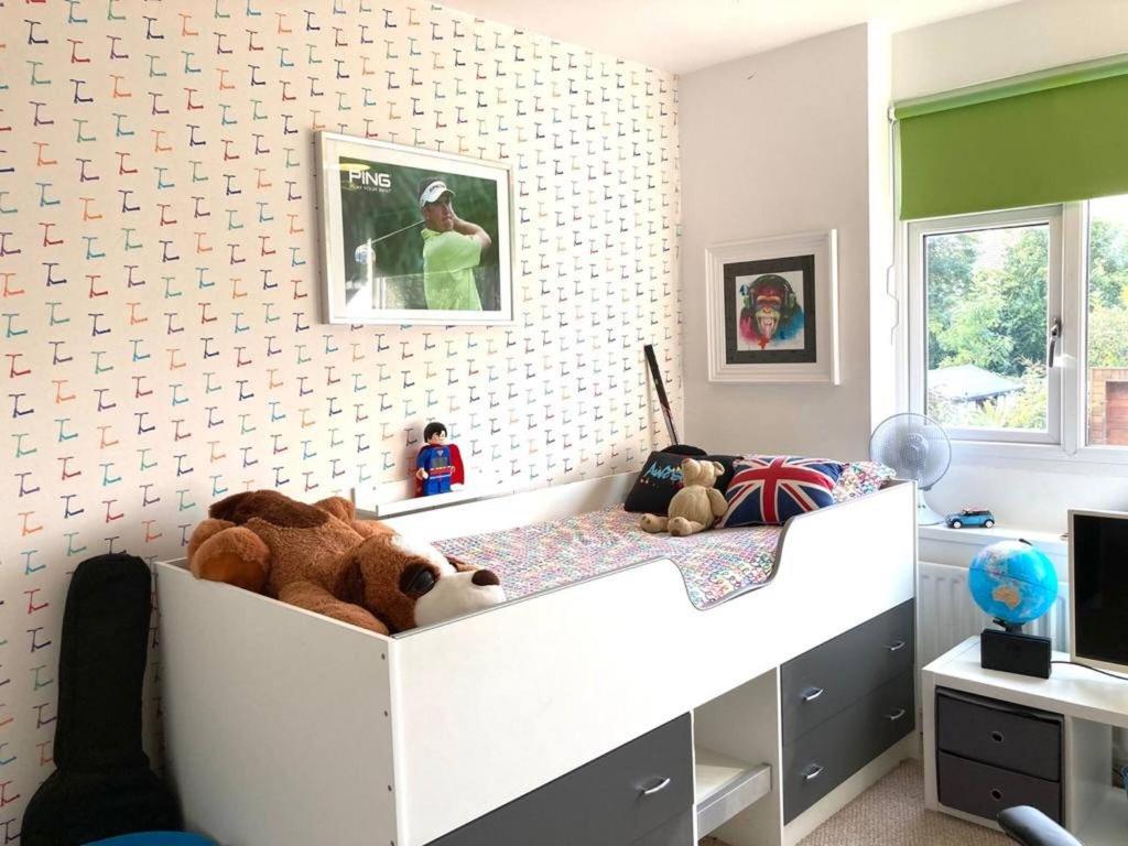 sypialnia z białym łóżkiem z pluszowym niedźwiedziem w obiekcie ire House Eire House w Coventry