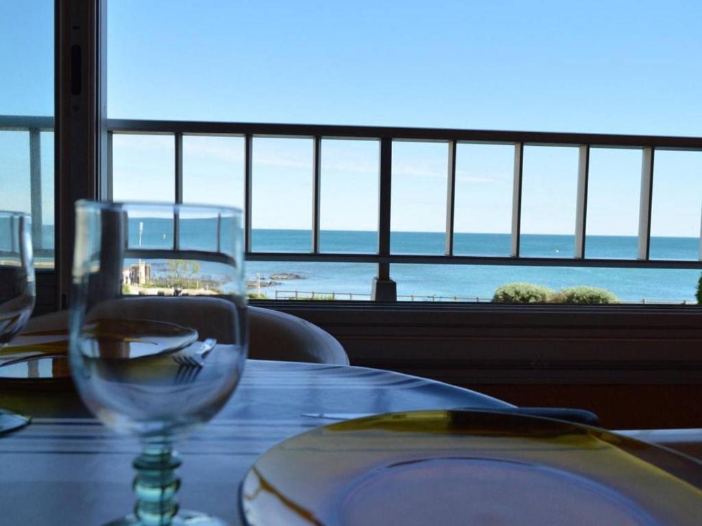 - une table avec des verres à vin et une vue sur l'océan dans l'établissement Appt cosy 4 pers à 100m de la plage avec parking privatif - FR-1-249-53, au Cap d'Agde