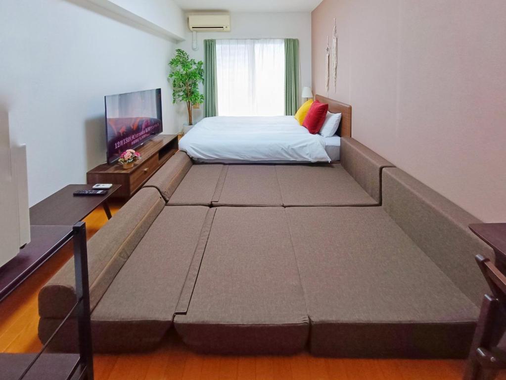 a large bed in a room with a large bed frame at Picoro Hakata - Vacation STAY 11333 in Fukuoka