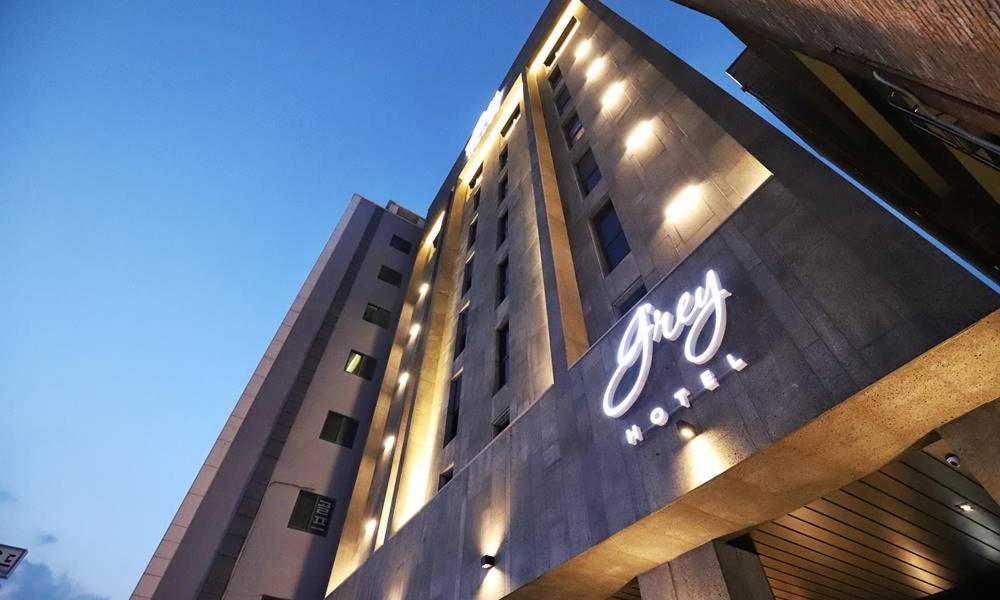 a building with a sign on the side of it at Gangneung Grey Hotel in Gangneung