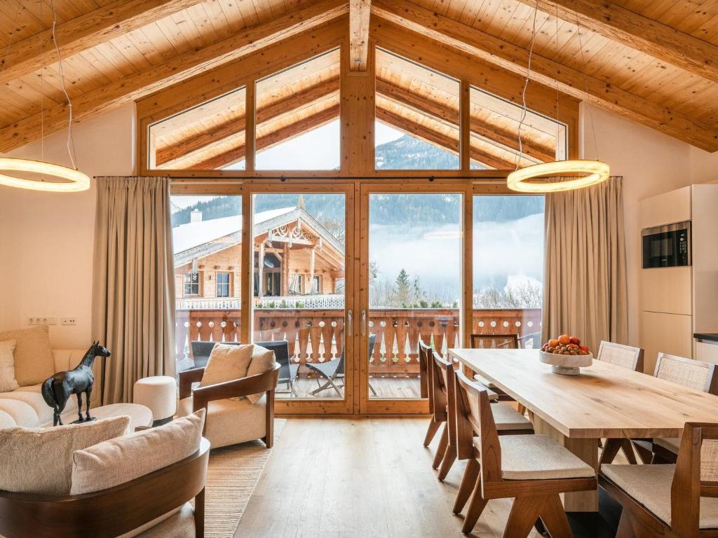 ein Esszimmer mit einem Tisch und einem großen Fenster in der Unterkunft Premium chalet with sauna on a sunny slope in Wald im Pinzgau