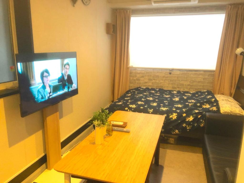 um quarto com uma cama e uma televisão na parede em Tokyo Art House em Tóquio