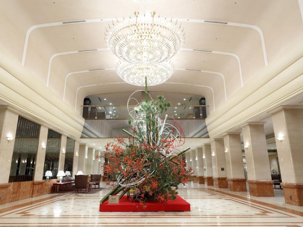 a large lobby with a chandelier and a large plant at Keio Plaza Hotel Tokyo in Tokyo