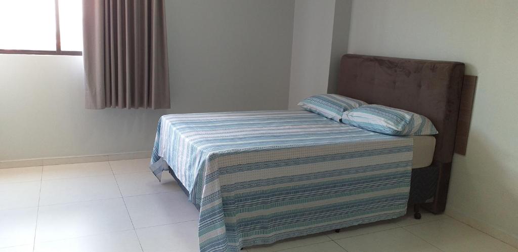 a small bedroom with a bed with a striped blanket at Maravilhoso Apt 709 Home Service próximo Shopping Partage e Rodoviária in Campina Grande