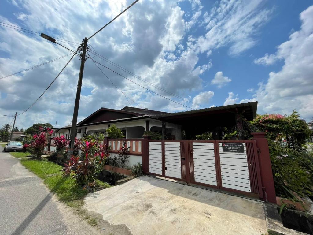 une maison avec un garage rouge et blanc dans l'établissement MIA FAMILIA HOMESTAY, à Cukai