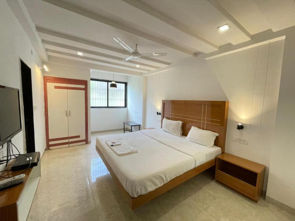 a bedroom with a bed and a flat screen tv at Hotel Holiday Pride in Aurangabad