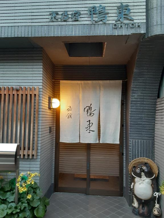 a front door of a building with a sign on it at OHTO Ryokan in Kyoto