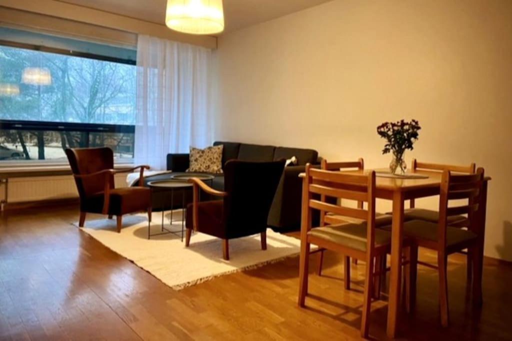 a living room with a table and chairs and a couch at Huoneisto Jalkarannassa in Lahti