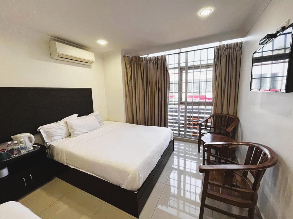 a hotel room with a bed and a window at Hotel Sagittario in Ipoh