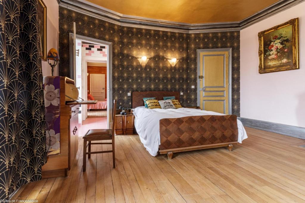 um quarto com uma cama e uma cadeira em Bonjour Guesthouse em Nevers