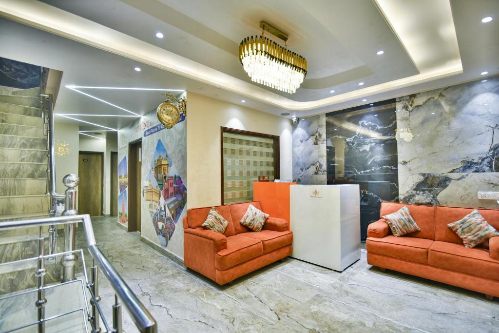 a lobby with two orange couches and a wall at Hotel Singh International, Amritsar in Amritsar