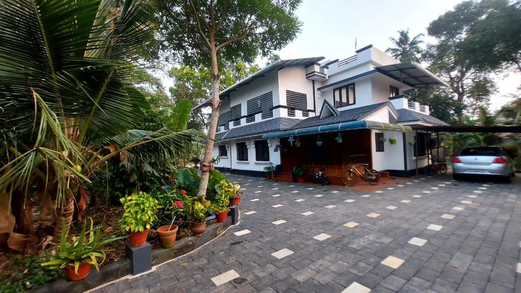 un coche aparcado frente a una casa con plantas en Grand marari, en Alleppey