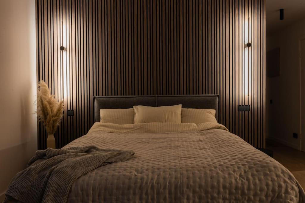 ein Schlafzimmer mit einem großen Bett mit gestreifter Wand in der Unterkunft Kalnu dzīvoklis (The hill condo) in Cēsis