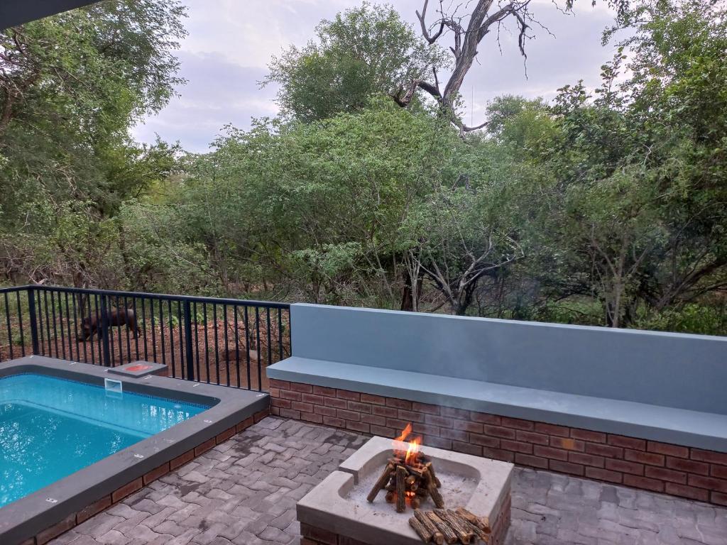 a swimming pool with a bench and a fire pit at Make a memory in Marloth Park