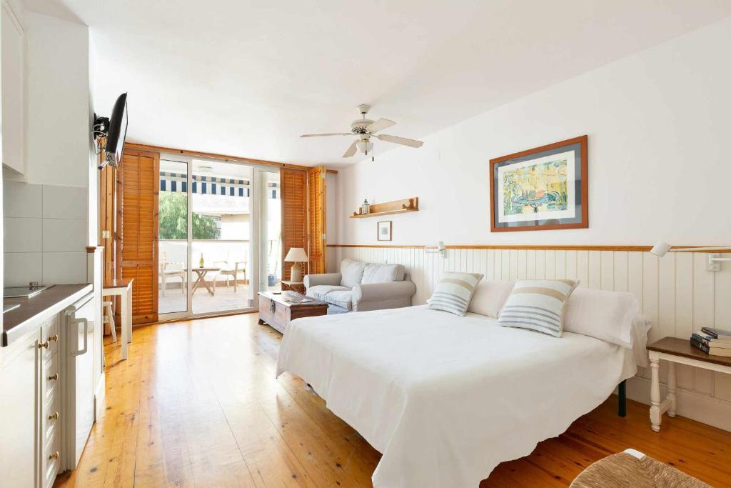 シッチェスにあるCentral a 10 minutos de la payaのベッドルーム(白いベッド1台付)、リビングルームが備わります。