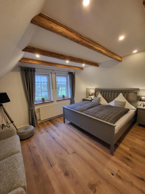 um quarto grande com uma cama grande e pisos em madeira em Ferienwohnung Krähling em Schmallenberg