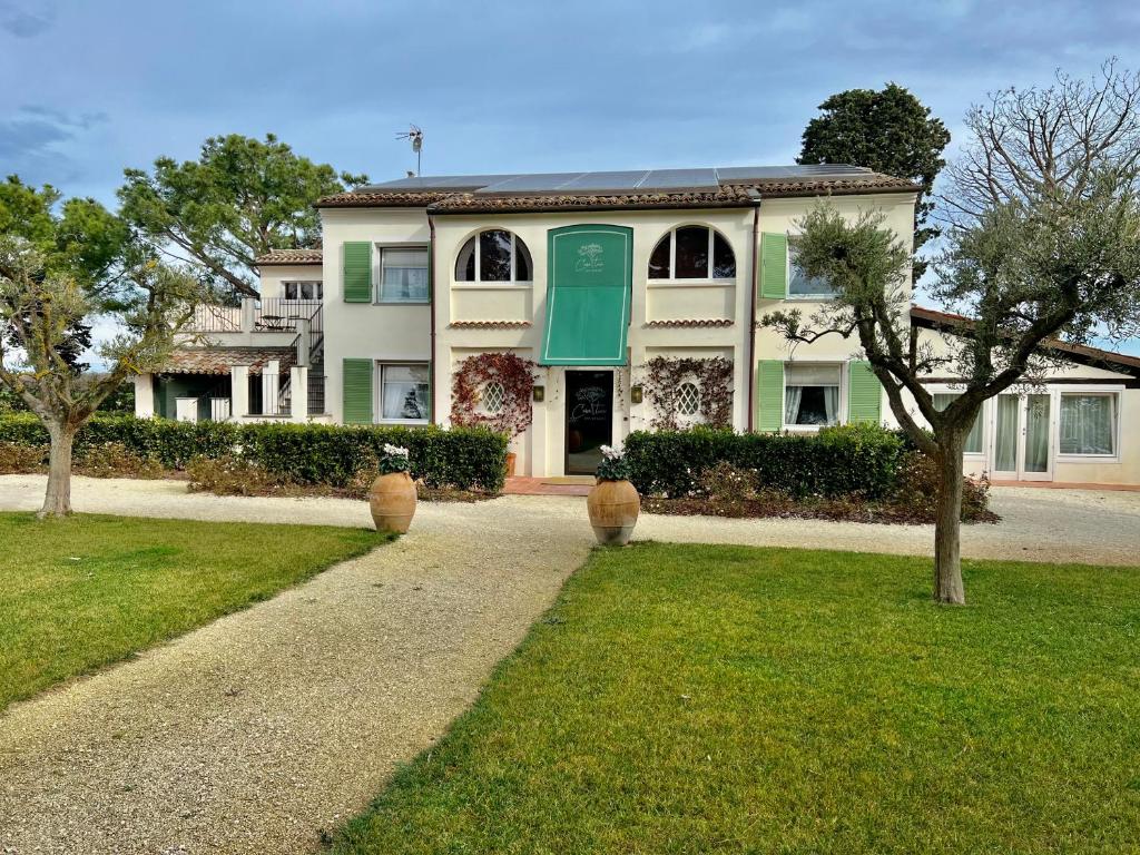 un edificio con una puerta verde y un patio de césped en Casa tua Spa Resort, en Porto Recanati