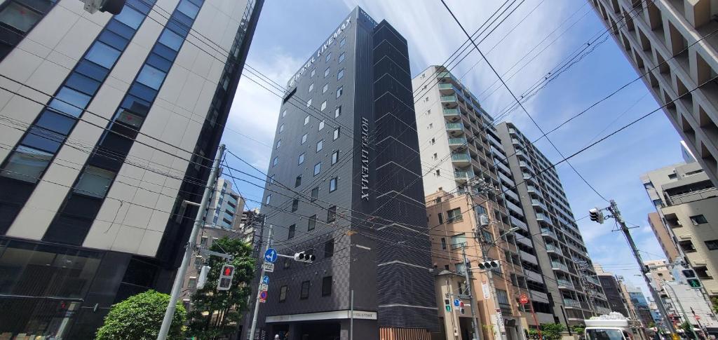 een hoog zwart gebouw midden in een stad bij HOTEL LiVEMAX Kamata Ekimae in Tokyo