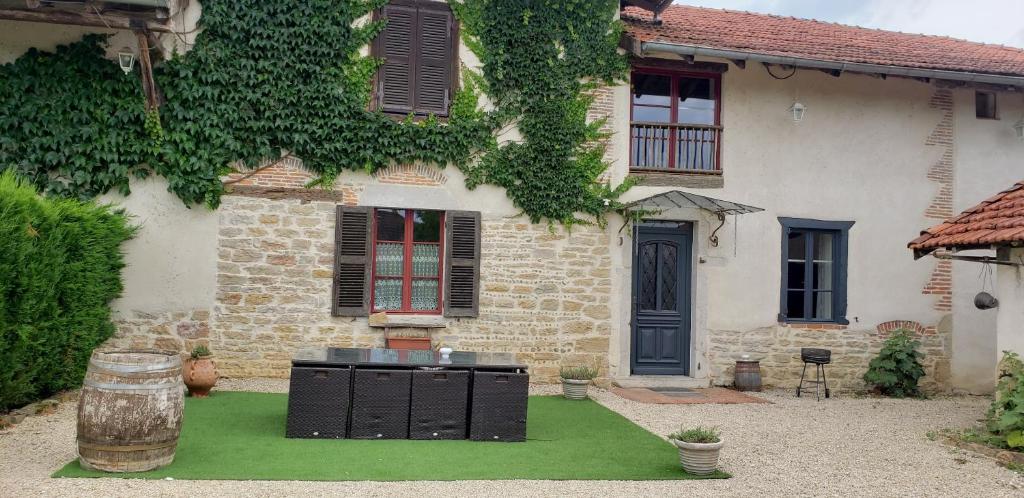 a house with a grill in the front yard at La Ferme du Tilleul in Foissiat