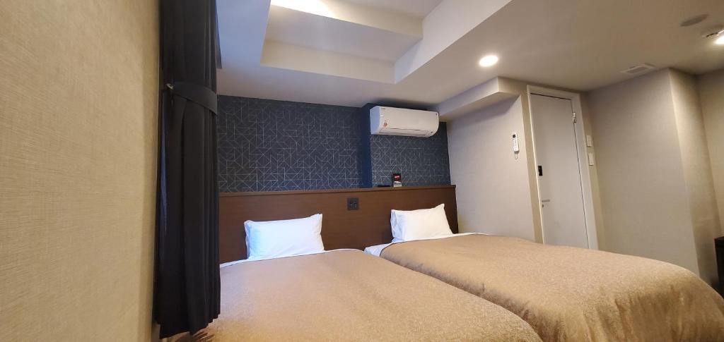 Postel nebo postele na pokoji v ubytování HOTEL LiVEMAX Kamata Ekimae