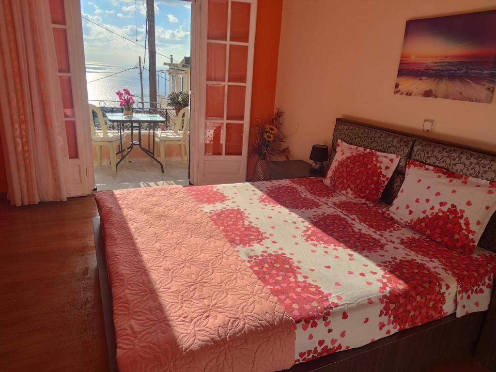 um quarto com uma cama com uma colcha vermelha e branca em Marios Apartment em Lákones