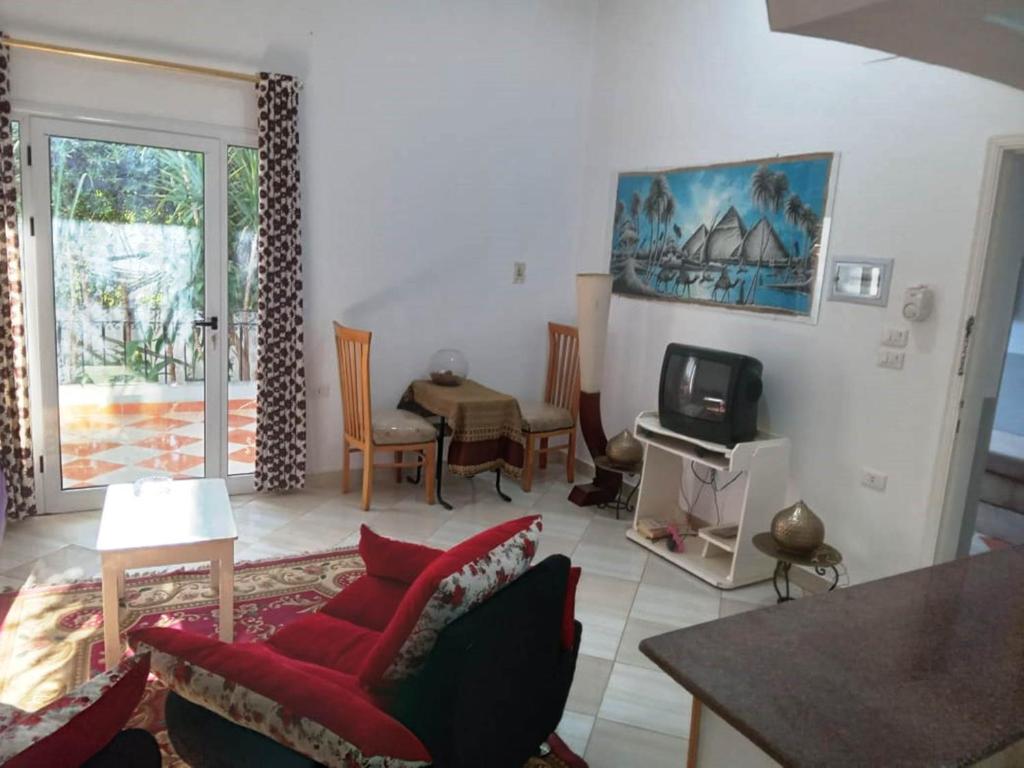 a living room with a red couch and a tv at Adam Flats 1 in Luxor