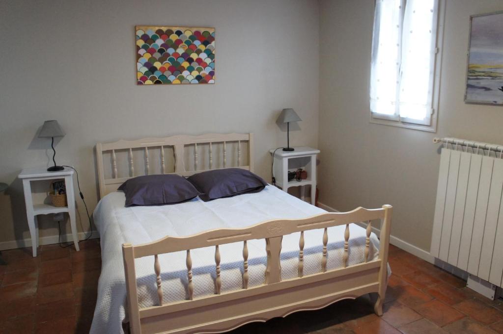 1 dormitorio con 1 cama con 2 mesitas de noche y una ventana en Chambre Coeur de Ville en Limoux