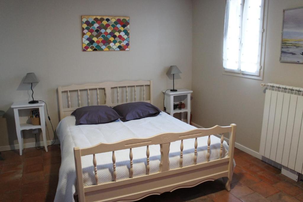sypialnia z łóżkiem z 2 stolikami nocnymi i oknem w obiekcie Chambre Coeur de Ville w mieście Limoux