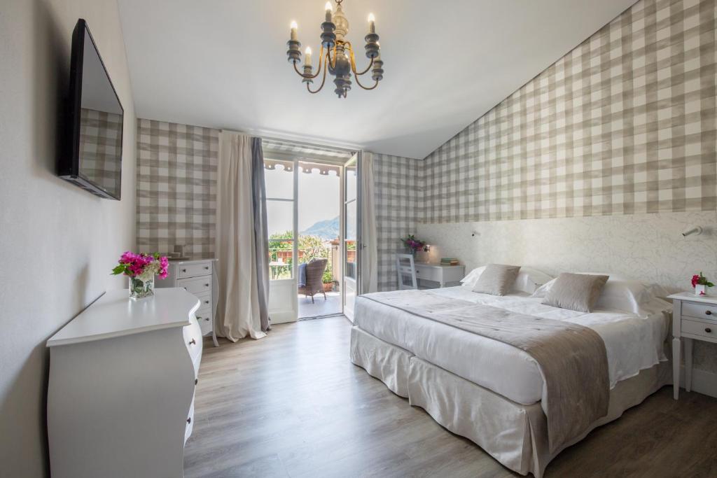 a bedroom with a large bed and a chandelier at Park Hotel Villa Belvedere in Cannobio