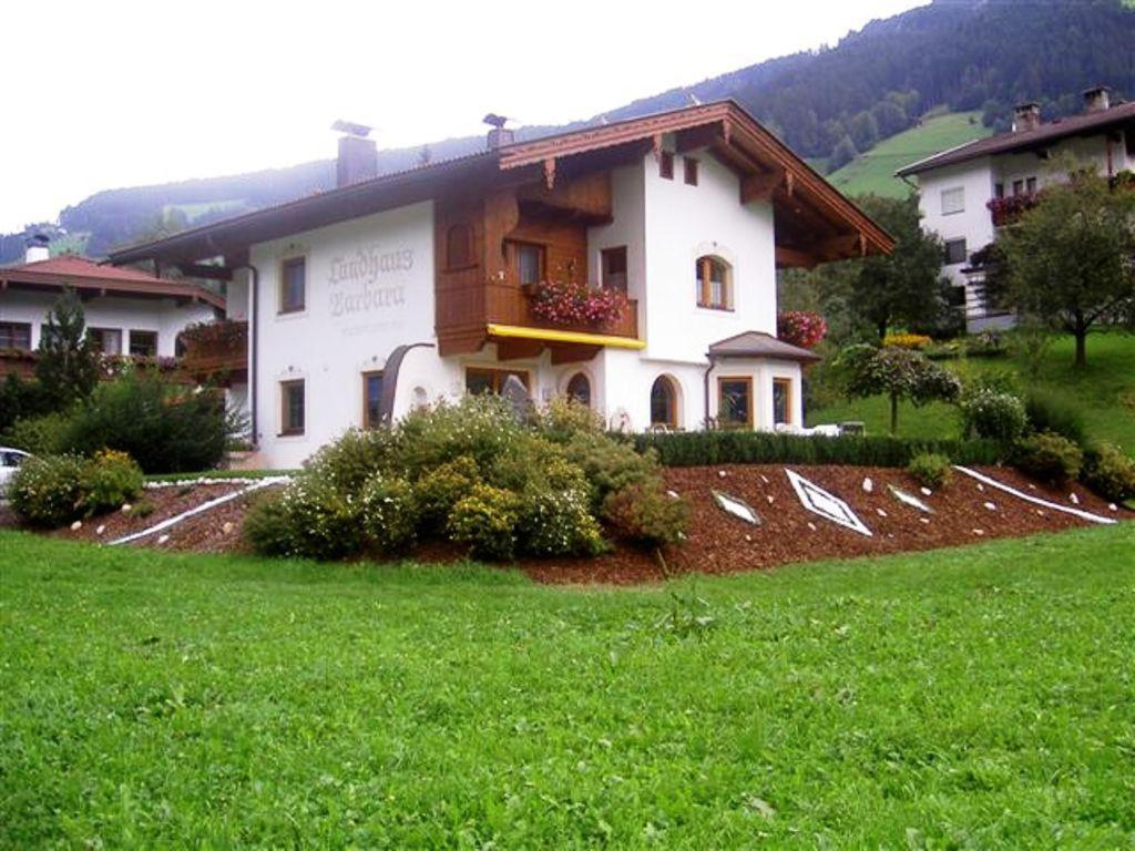 una casa con un césped verde delante de ella en Landhaus Barbara en Ramsau im Zillertal