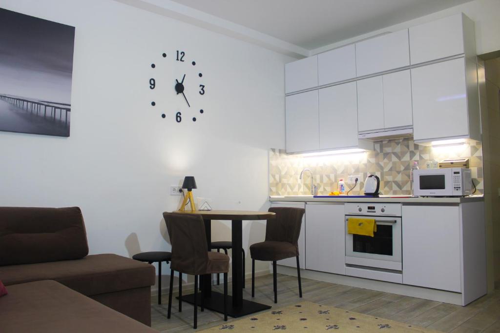 a kitchen with a table and a clock on the wall at Sweet Home in Kyiv