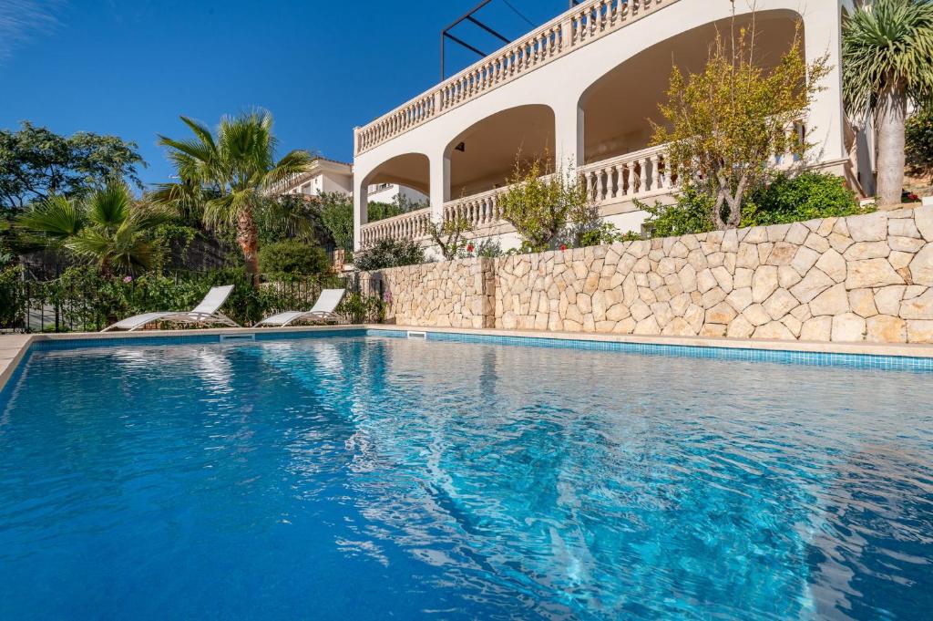 a swimming pool in front of a house at Villa Bendinat 10 - by Priority Villas in Portals Nous