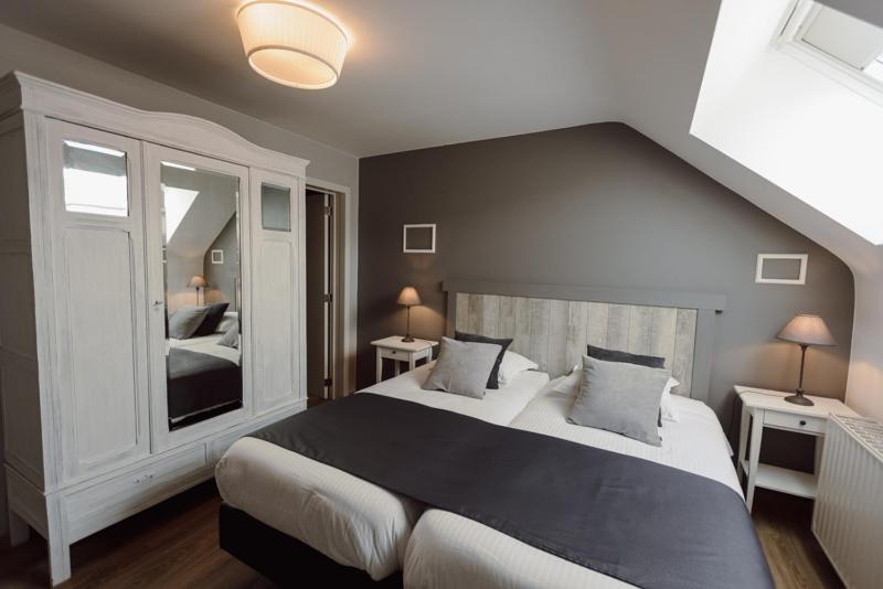 a bedroom with a large bed and a mirror at Le Relais De La Motte in Soignies