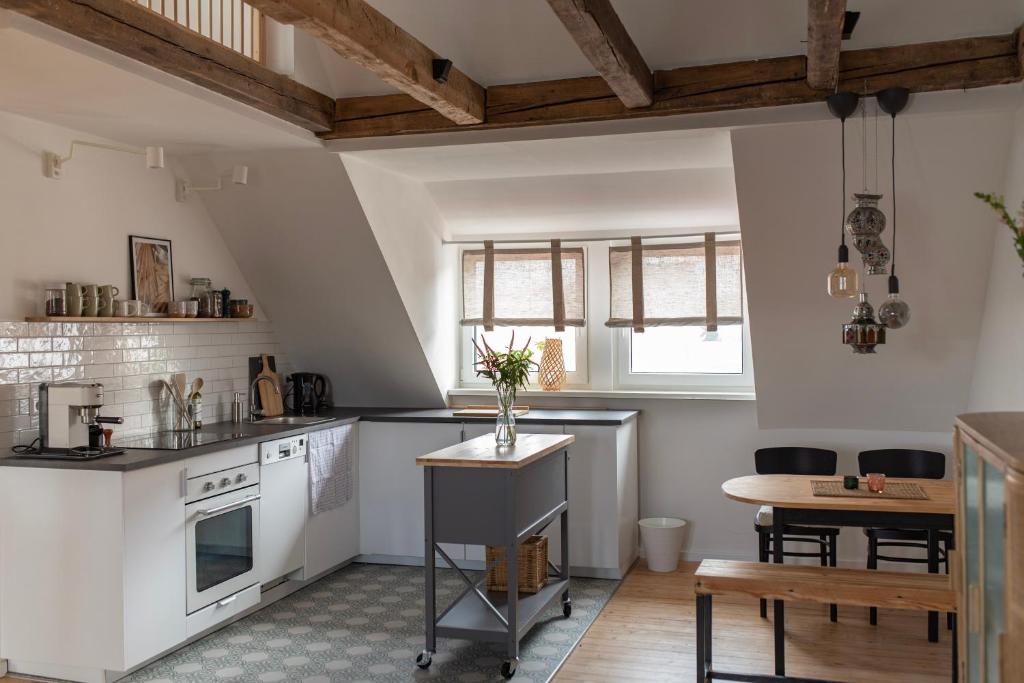 een keuken met witte werkbladen en een tafel en een tafel bij Altbau Appartement - klein aber oho in Aschaffenburg