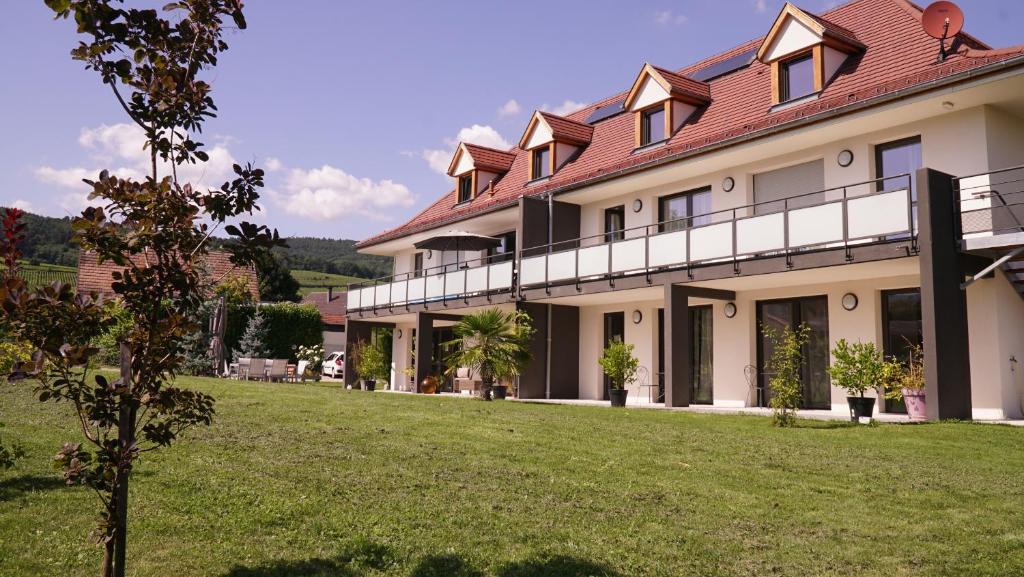 una casa grande con un césped verde delante de ella en Maison d'Hôtes Sainte Hune Chambres en Hunawihr