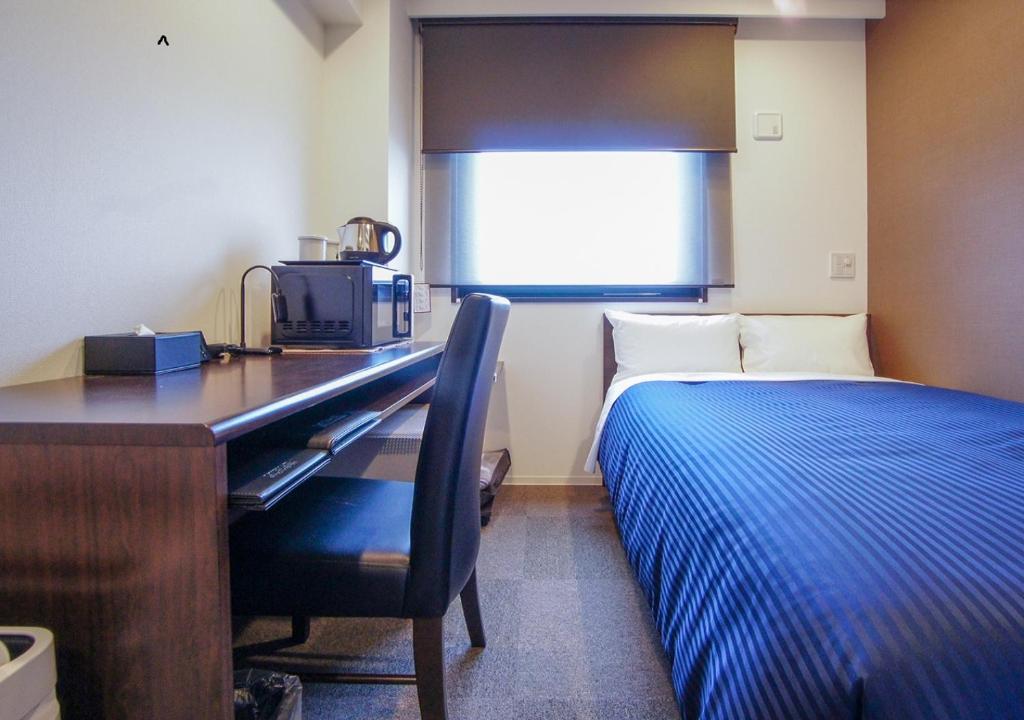 Postel nebo postele na pokoji v ubytování HOTEL LiVEMAX Kanazawa Ekimae