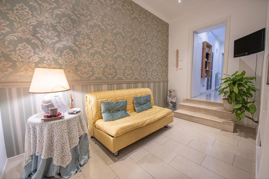 een woonkamer met een gele stoel en een tafel bij Refuge on Piazza re di Roma in Rome
