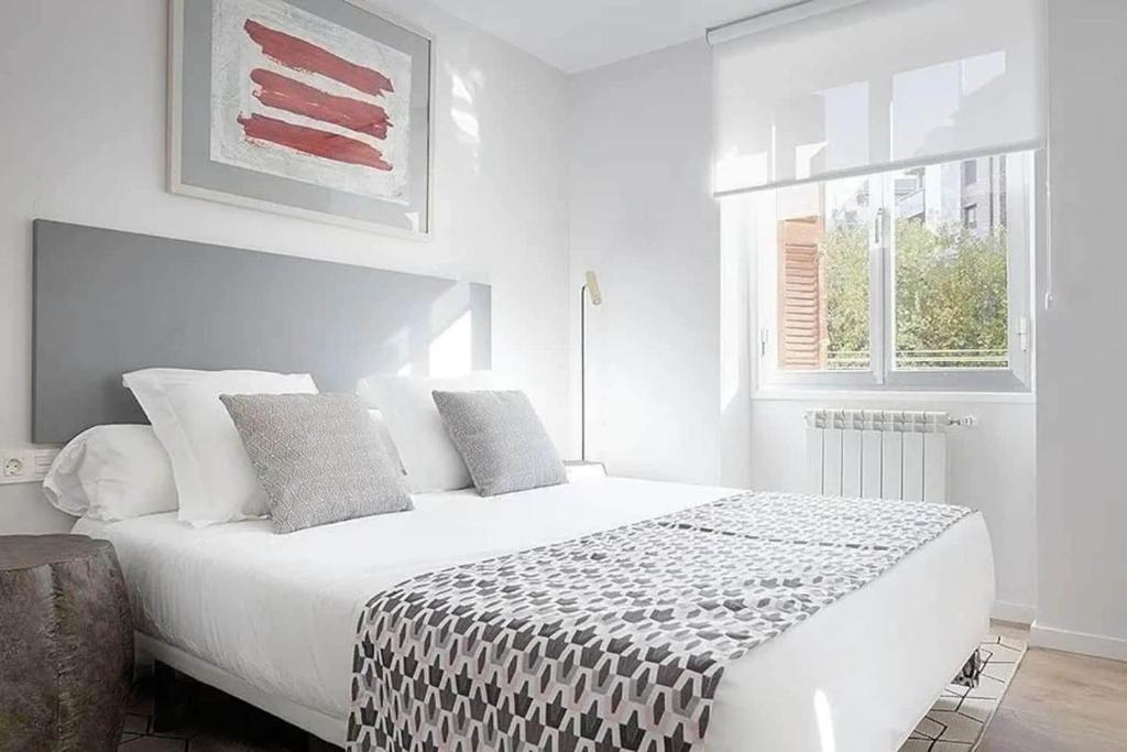 ein weißes Schlafzimmer mit einem großen weißen Bett mit Kissen in der Unterkunft Apartamento Aizkorri by SanSe Holidays in Añorga-Lugariz