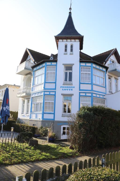 een blauw-wit gebouw met een zwart dak bij Pension Lotte in Kühlungsborn