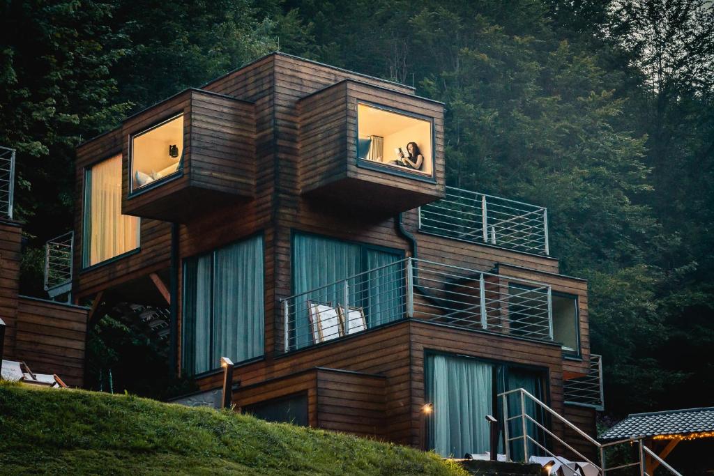 drewniany budynek z balkonami na szczycie wzgórza w obiekcie Apartamenty Szuflandia w Wiśle