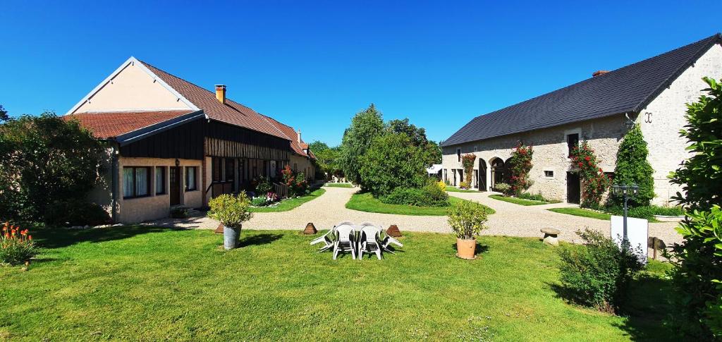 a table and chairs in a yard next to a building at Domaine Des Médards in Beaulieu-sur-Loire