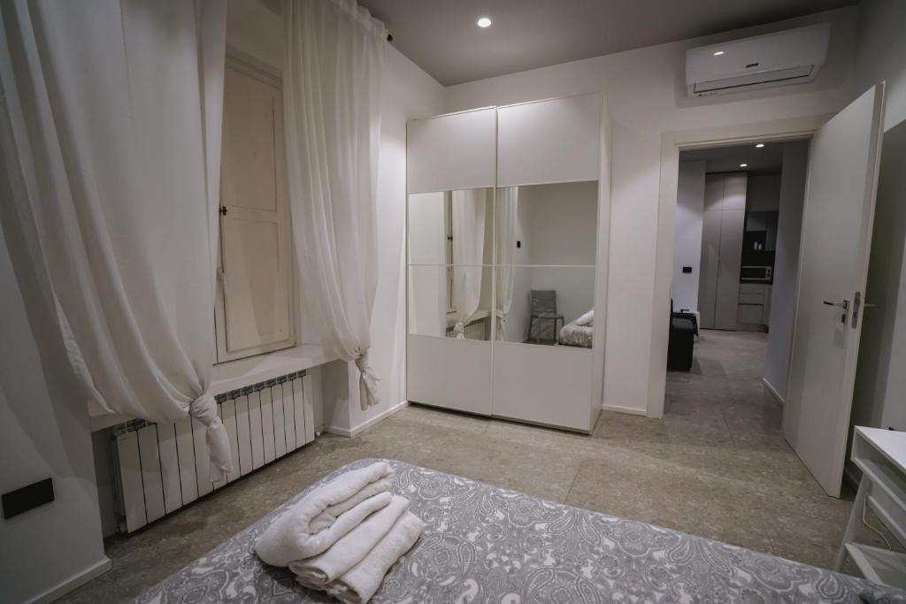 een badkamer met witte handdoeken op de vloer en een spiegel bij De Luca 6 Apartments in Salerno