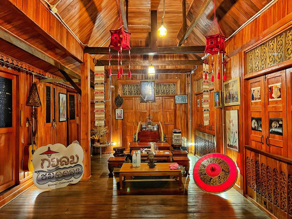 una stanza con pareti in legno e una stanza con tavoli di กิ่วลม - ชมลคอร Kiwlom - Chomlakorn, Lampang, TH a Lampang