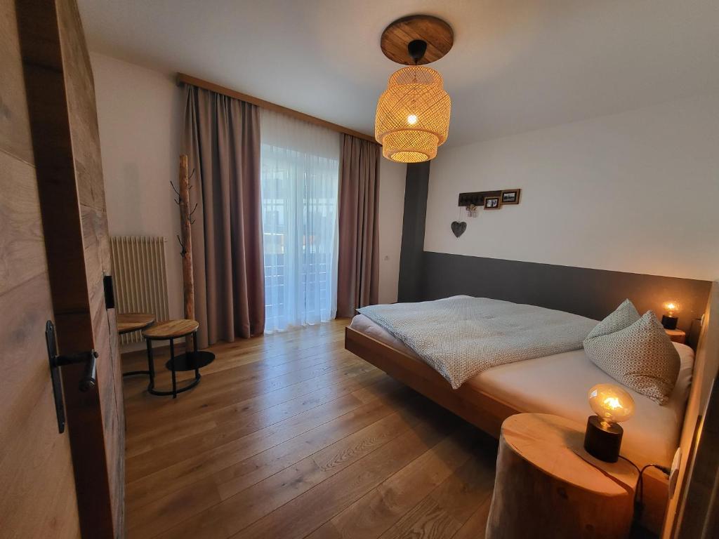 Habitación de hotel con cama y lámpara en Appartements Krautgasser, en San Candido